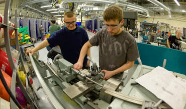 Two student working with manufacturing machine