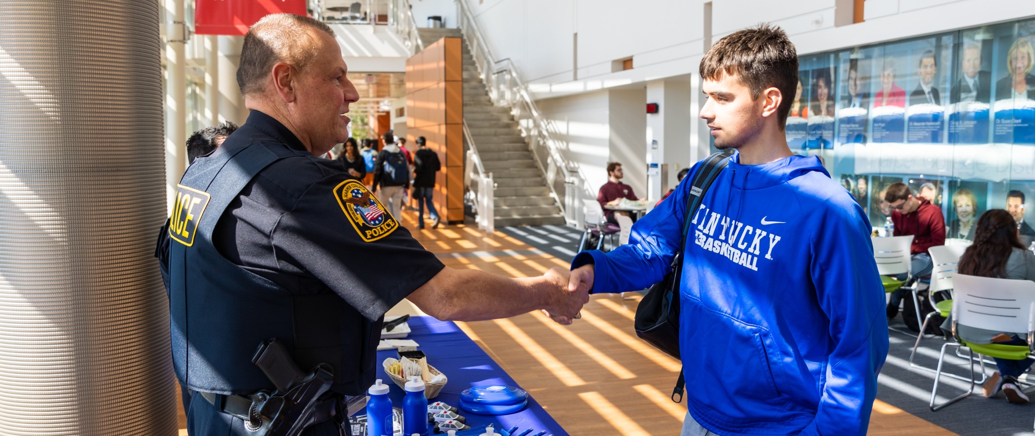 Police officer shaking hands with student