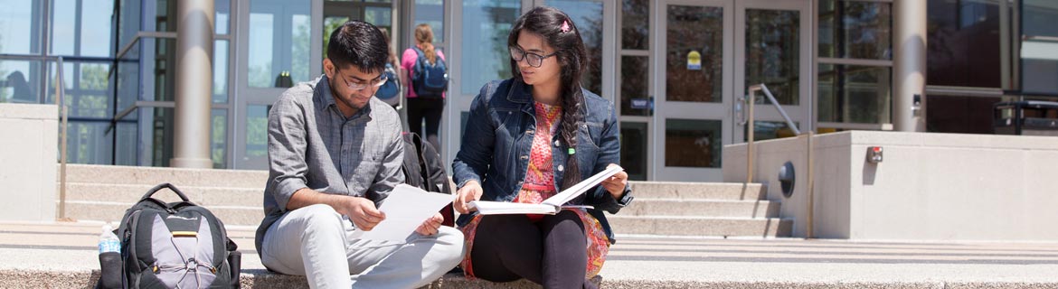 Two Harper students sit on steps outside Avante