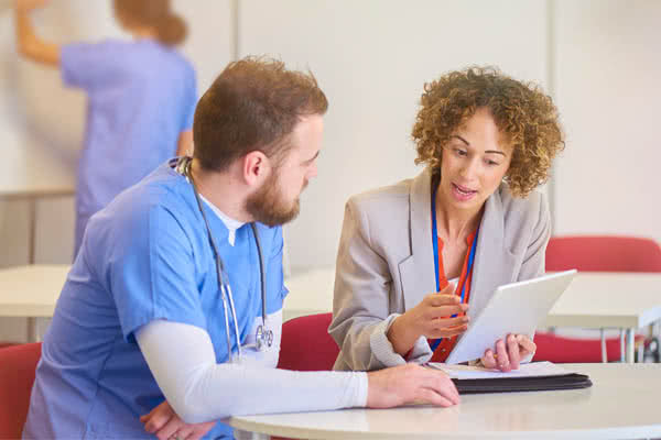 Health Information Technician reviewing information with healthcare worker