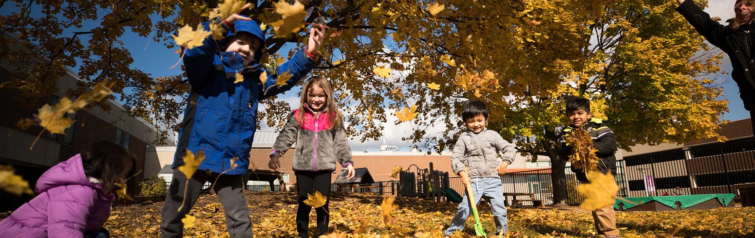 Children playing in leaves at the Early Childhood Laboratory School.